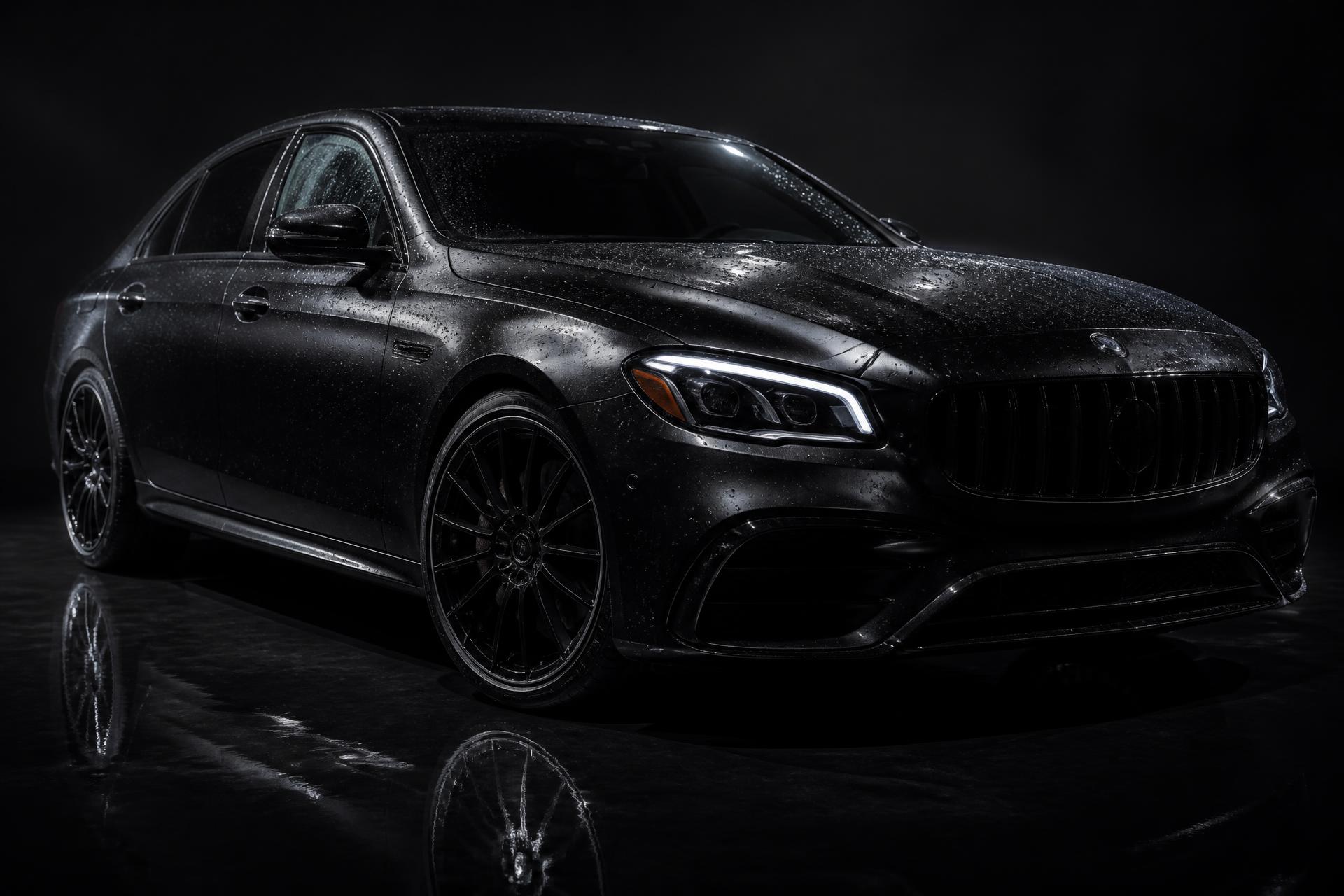 Luxury black vehicle with water droplets after professional detailing